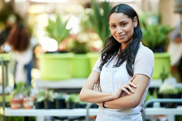 Portrait of a young female business owner standing with her arms crossed in her nursery.