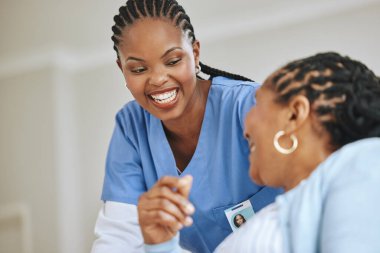 Shot of a nurse speaking to her female patient.
