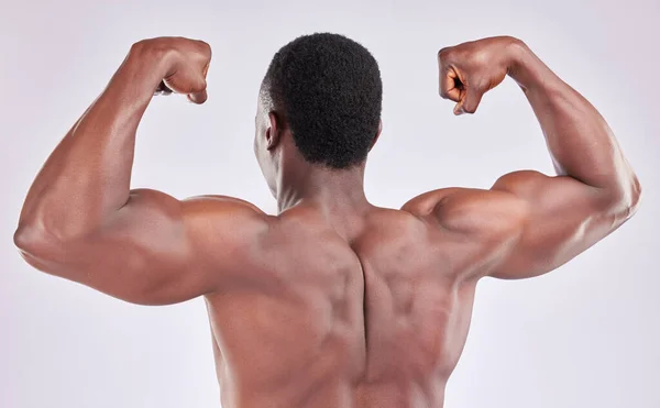 Estudio Joven Musculoso Flexionando Sus Brazos Sobre Fondo Gris — Foto de Stock