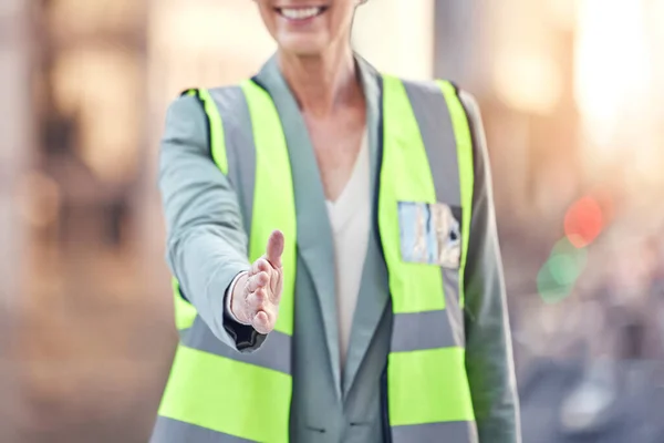 Cropped shot of an unrecognizable female construction worker gesturing for a handshake while standing on a building site.