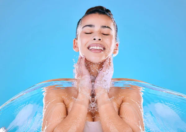 青い背景に水を浴びせられている美しい若い女性のショット — ストック写真