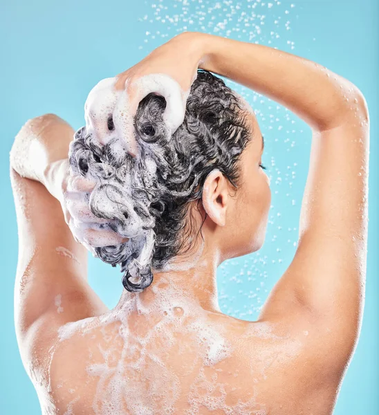 在淋浴间用蓝色背景洗头发的年轻女人被枪击中 — 图库照片