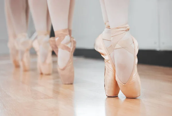 Shot of a group of ballerina dancers practicing a routine in their pointe shoes.