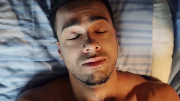 Видеозапись Молодого Человека Выглядящего Уставшим Напряженным Лежа Постели Дома — стоковое видео
