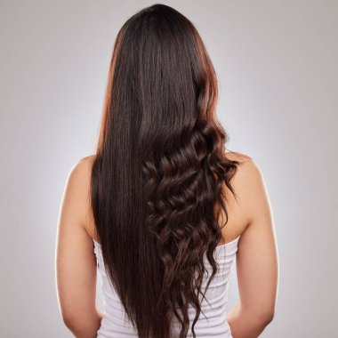 Shot of a woman posing with half straightened and half curled hair.