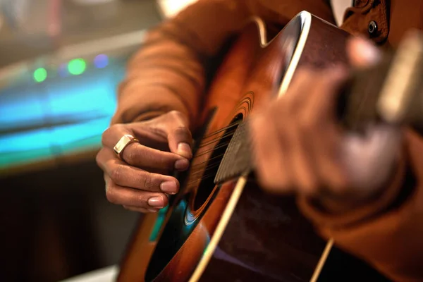 Cropped shot of an unrecognizable male musician playing his guitar at home.