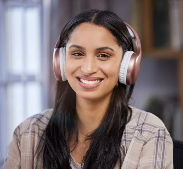 Shot of a young student using headphones while studying at home.