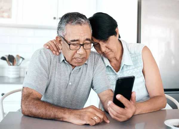 Shot Senior Couple Looking Unhappy While Using Phone Home — Stockfoto
