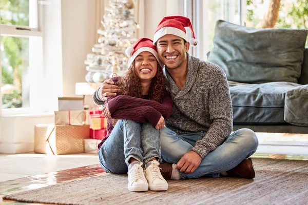 Evde Otururken Noel Şapkası Takan Genç Bir Çiftin Fotoğrafı — Stok fotoğraf