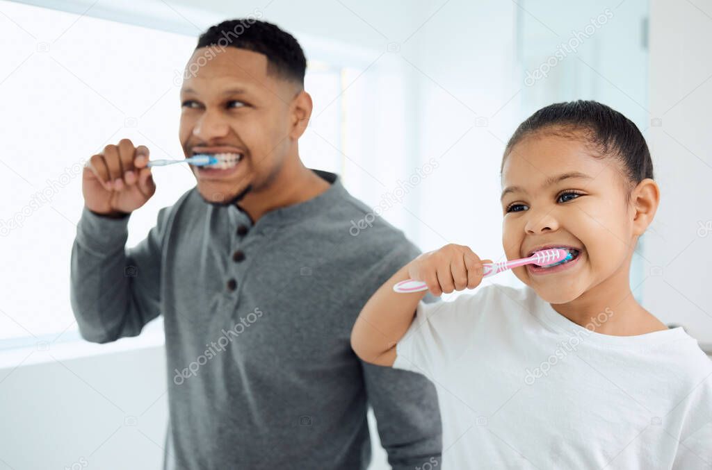 Shot of an adorable little girl and her father brushing their teeth together at home.