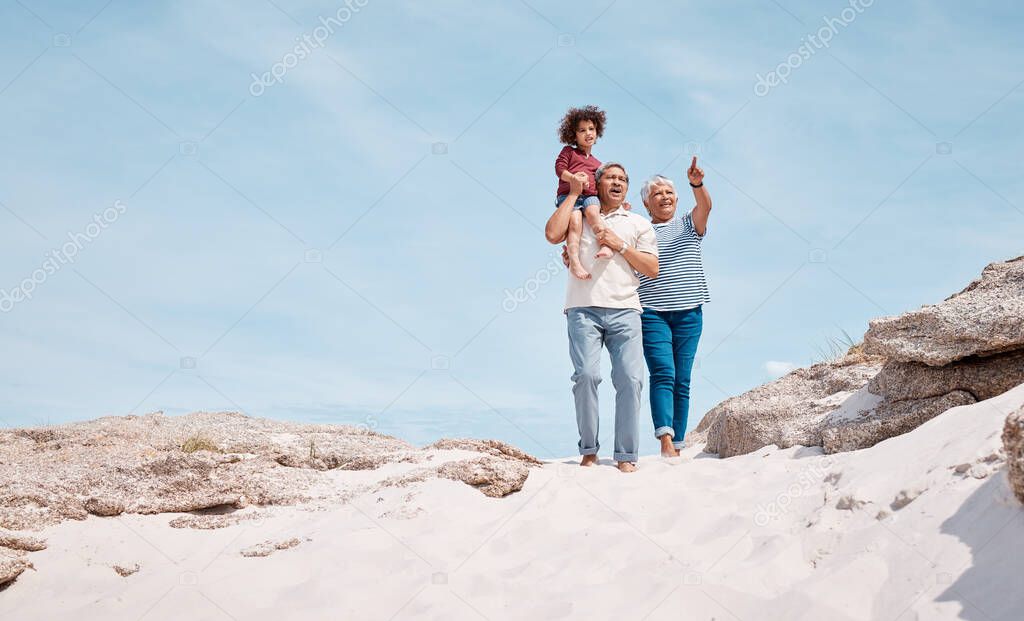 Shot of an adorable little boy at the beach with his grandparents.