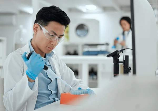 Shot of a young man filling a test tube samples.