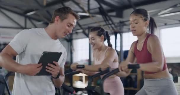 Gym Instructor Checking Trainees Progress Adjusting Limit Exercise Cycle Machine — Wideo stockowe