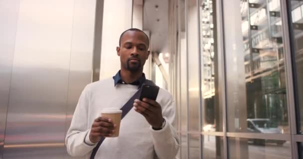 Βίντεο Έναν Νεαρό Επιχειρηματία Πίνει Καφέ Και Χρησιμοποιεί Κινητό Ενώ — Αρχείο Βίντεο
