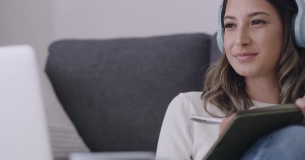 Wanita Yang Mendengarkan Musik Pada Headphone Menulis Dalam Buku Harian — Stok Video