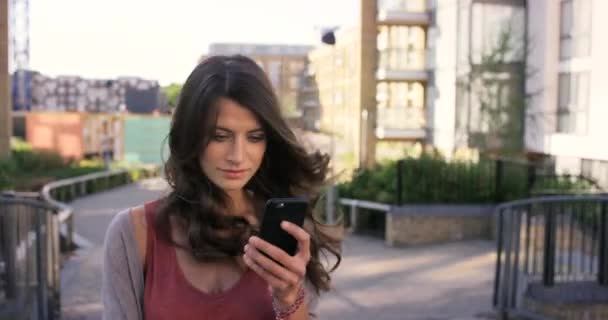 Imágenes Video Una Mujer Usando Teléfono Celular Mientras Camina Afuera — Vídeos de Stock