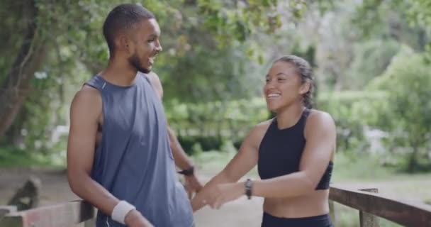两个健康的人在公园跑步时拥抱在一起 享受户外运动和健身的形象 一对带着自信的微笑慢跑的夫妇 在一个安静的风景区一起锻炼 — 图库视频影像