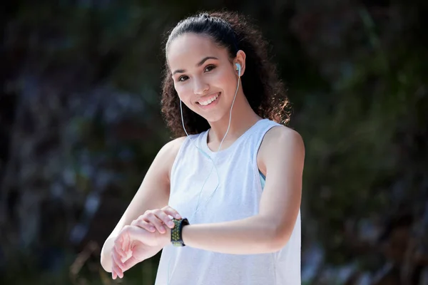 Sporty Young Woman Wearing Earphones Using Smartwatch While Standing — Zdjęcie stockowe