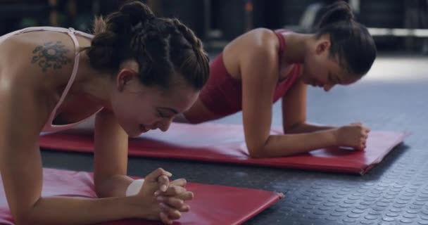 女运动员在体育馆内的垫子上做跳板运动 积极健康的朋友一起做耐力锻炼 强壮的女运动员为自己的健康和健康建设核心力量 — 图库视频影像