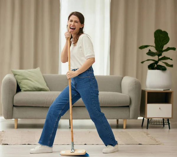 Young Woman Singing While Sweeping Floors Home — Stok fotoğraf