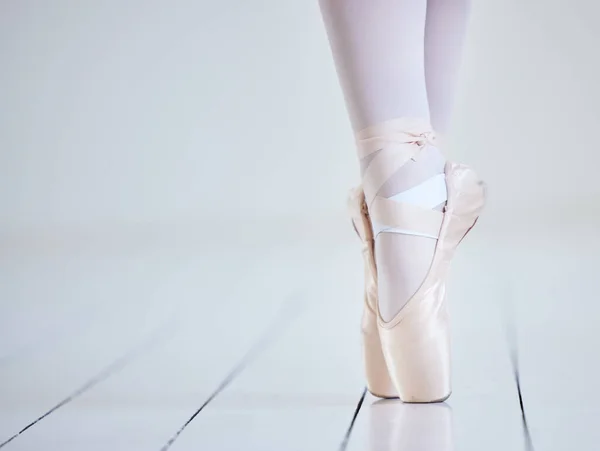 an unrecognisable woman dancing in a ballet studio.