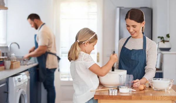 Adorable Little Girl Assisting Her Mother While Baking Home — Stockfoto