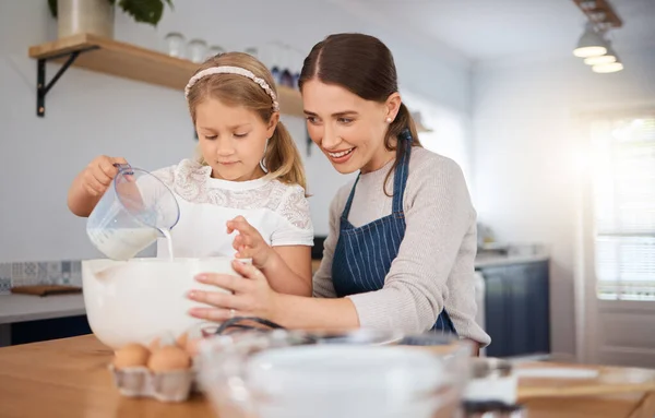 Adorable Little Girl Assisting Her Mother While Baking Home — Stockfoto