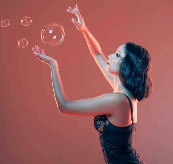 Красивая Молодая Женщина Позирует Студии Окружении Пузырьков Красном Фоне — стоковое фото
