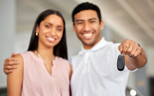 a young couple showing their car keys.