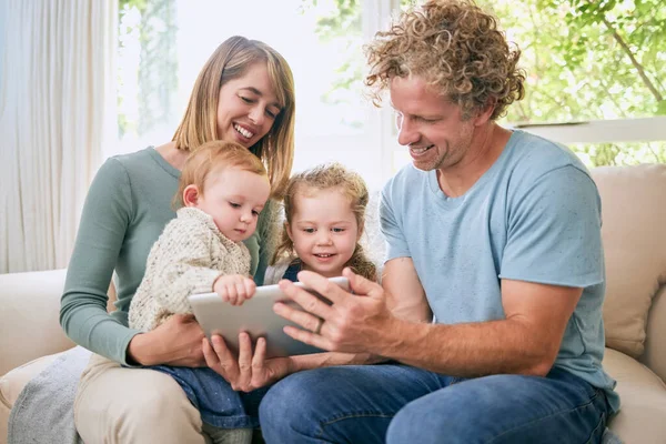 Młoda Rodzina Szczęśliwie Nawiązująca Więź Podczas Korzystania Tabletu Cyfrowego Kanapie — Zdjęcie stockowe