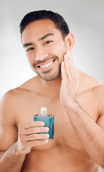 Studio Shot Handsome Young Man Applying Aftershave His Face While — Stok Foto