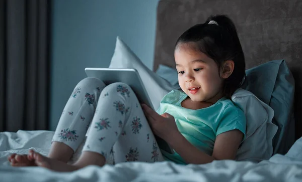Little Girl Using Digital Tablet While Lying Her Bed — Stock Fotó