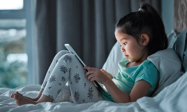 Little Girl Using Digital Tablet While Lying Her Bed —  Fotos de Stock