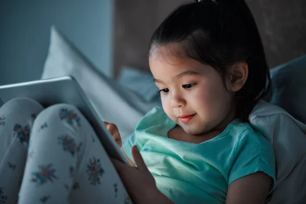 Una Bambina Che Usa Tablet Digitale Mentre Sdraiata Sul Letto — Foto Stock