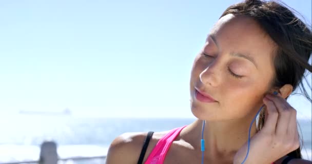 Video Footage Woman Using Her Earbuds Listen Music While Running — Stockvideo