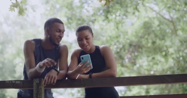 Two Joggers Using Phone Park Looking Fitness App Break Happy — Vídeo de stock