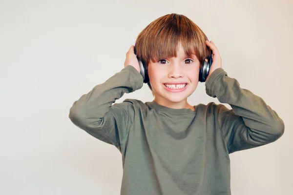 Studyjne Ujęcie Słodkiego Chłopca Używającego Słuchawek Pozującego Ścianę — Zdjęcie stockowe