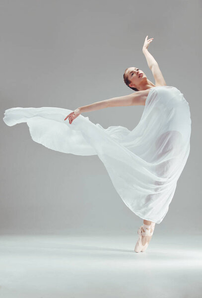 Full length shot of an attractive young ballerina dancing alone in the studio.