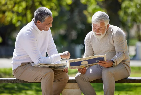 Two Senior Men Sitting Together Bench Park Reading Newspaper — 图库照片