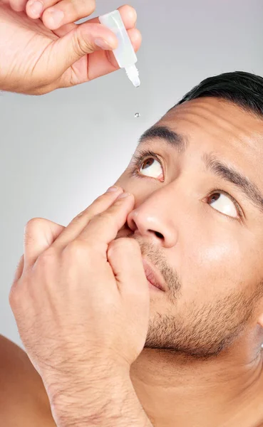 Studio Shot Handsome Young Man Applying Eye Drops Grey Background — Stok fotoğraf