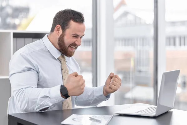 Joven Empresario Animando Mientras Trabaja Ordenador Portátil Una Oficina — Foto de Stock