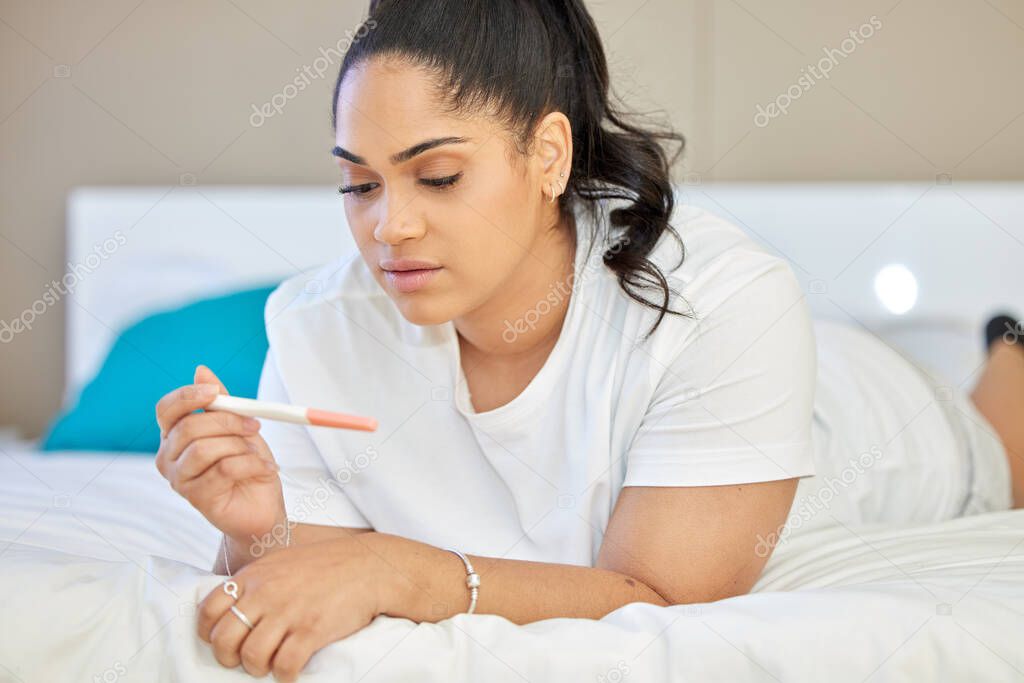 a young woman taking a pregnancy test at home.