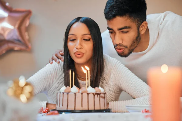 Young Couple Blowing Candles Cake While Celebrating Birthday Home — Zdjęcie stockowe