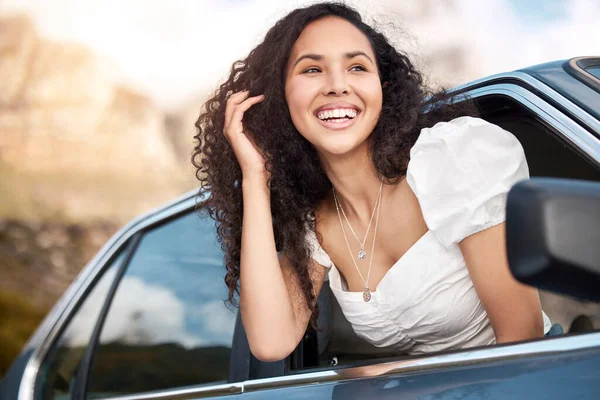 a beautiful young woman leaning out the car window.