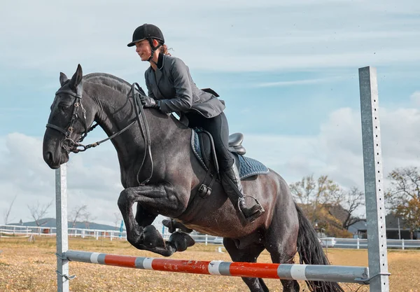 Eine Junge Reiterin Springt Mit Ihrem Pferd Über Eine Hürde — Stockfoto