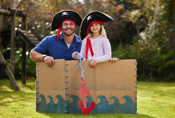a father and daughter dressed up like pirates outside in the yard.