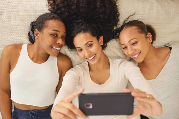 Three Girlfriends Taking Selfie While Lying Bed Together — Foto de Stock