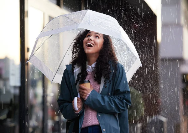 a young woman admiring the rain in the city.