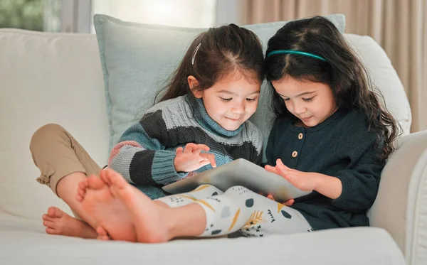 Two Young Sisters Using Digital Tablet Together Sofa Home — Foto Stock