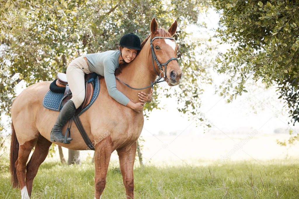 an attractive young woman standing with her horse in a forest.